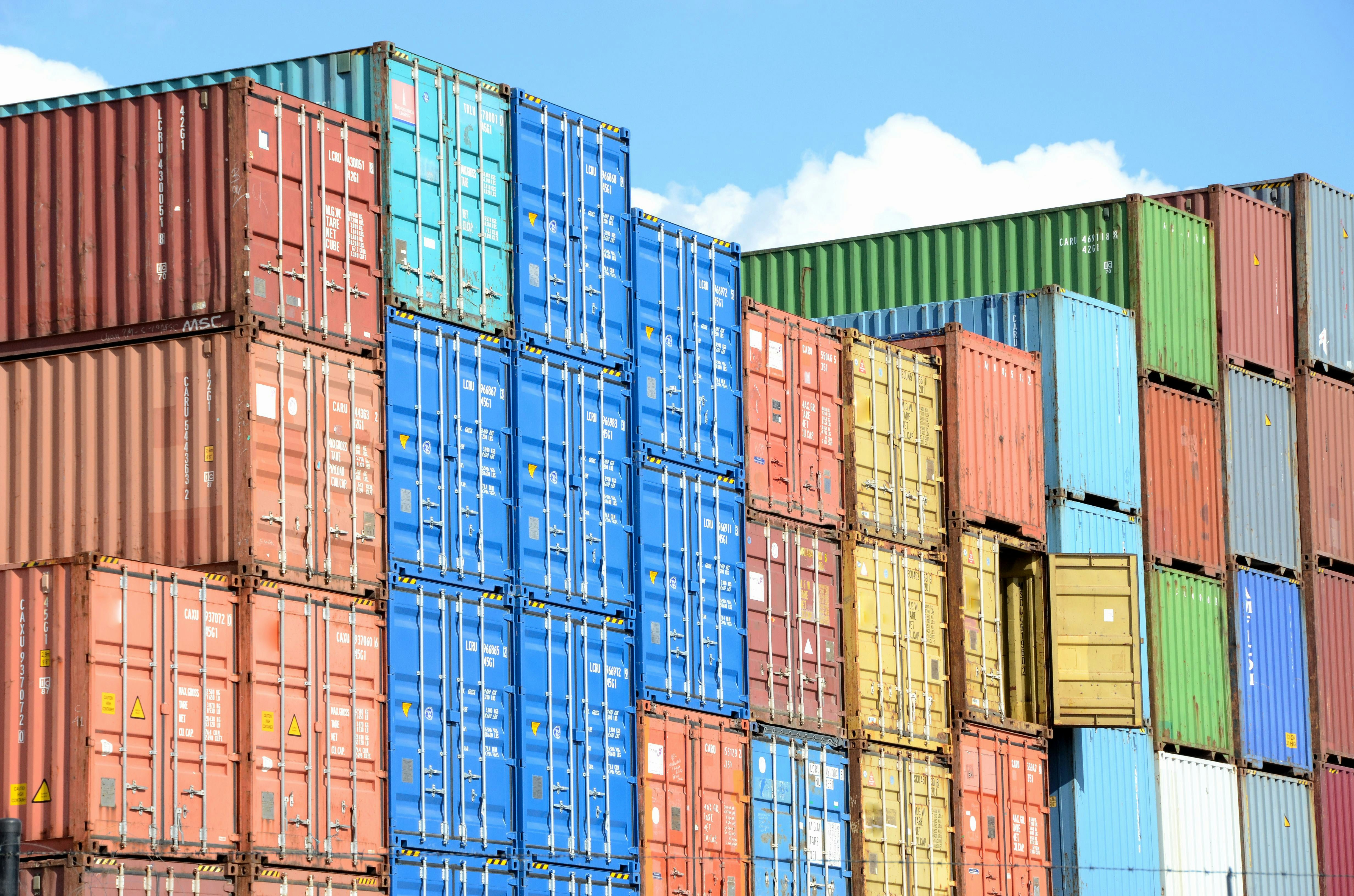 Photo by Paul Teysen on Unsplash; stacked intermodal containers in different colours.